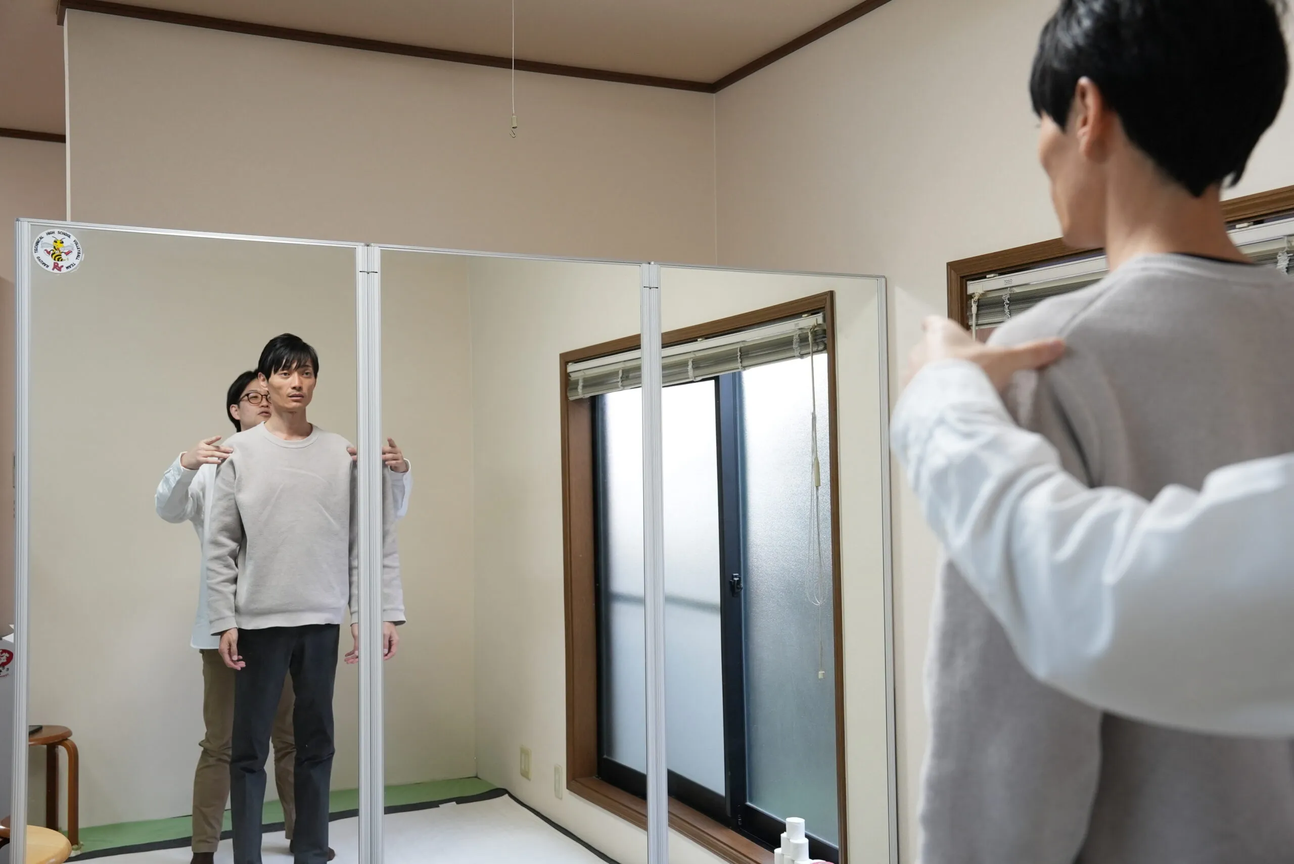 鏡の前で来院者の姿勢と重心を確認している様子